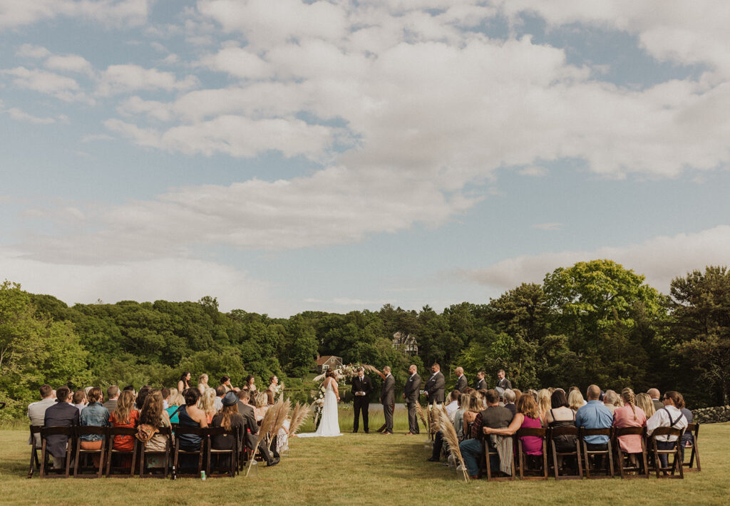 outdoor ceremony at bourne farm with circular arbor and boho pampas grass aisle markers 