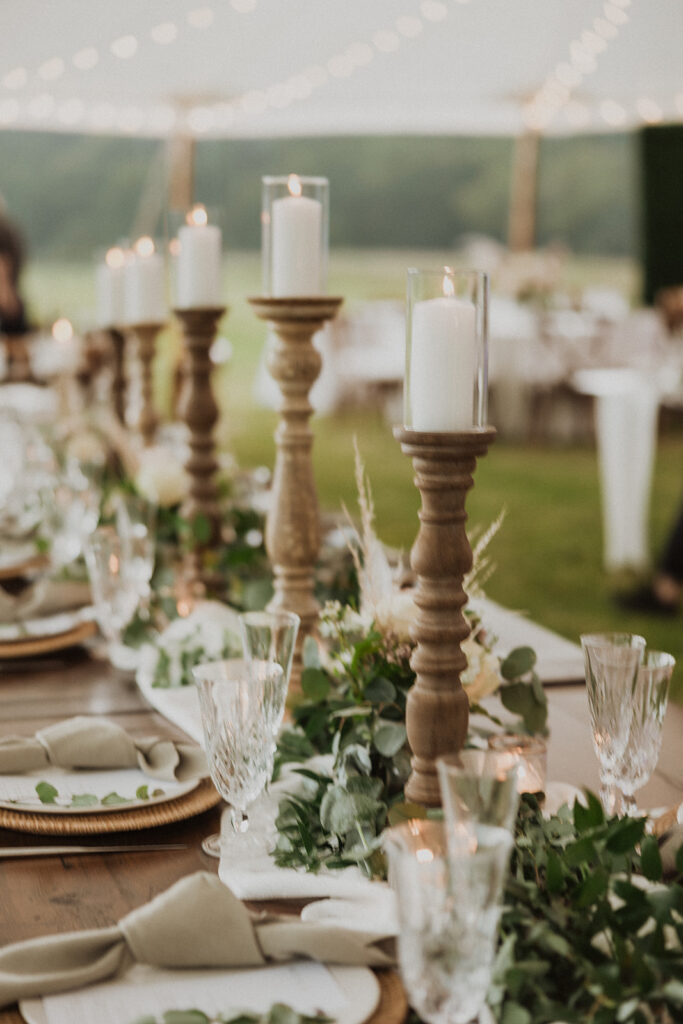  Rattan charger plates and knotted napkins. Long farm tables lined with greenery and candle light